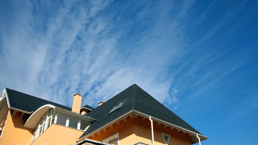 Roofline and chimney against a blue sky
