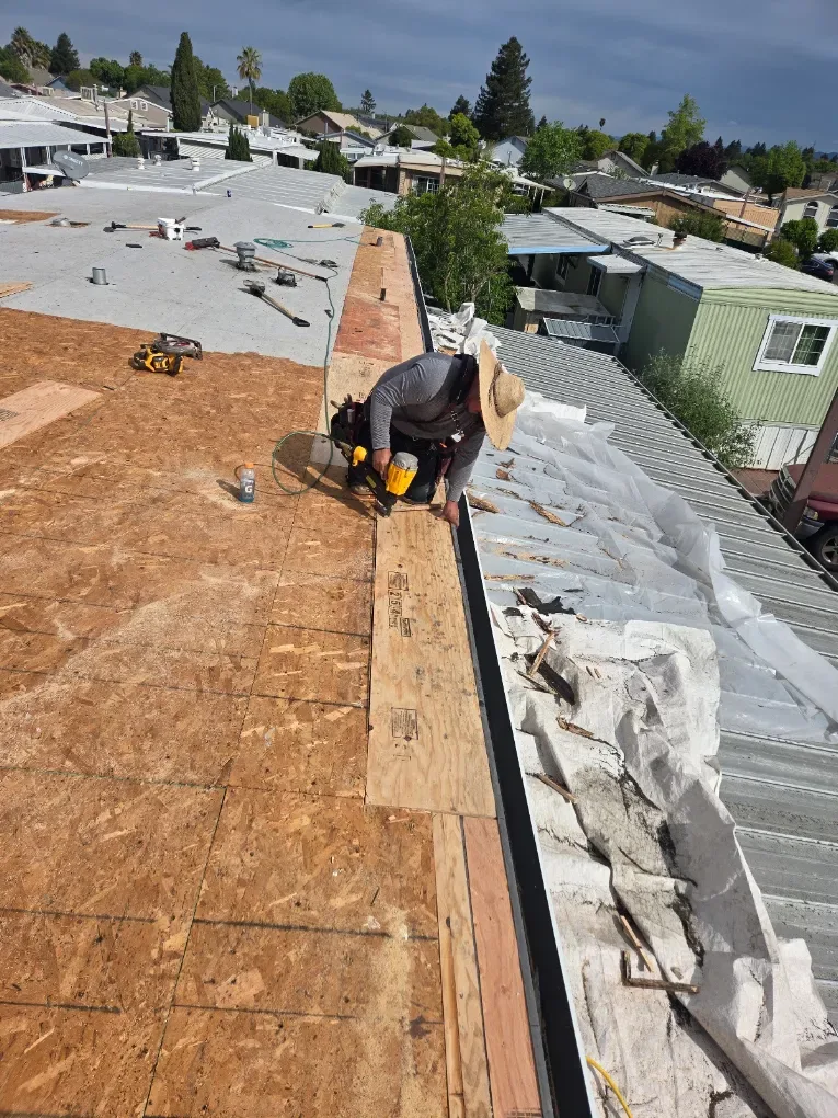Roofer working on exposed decking during roof installation