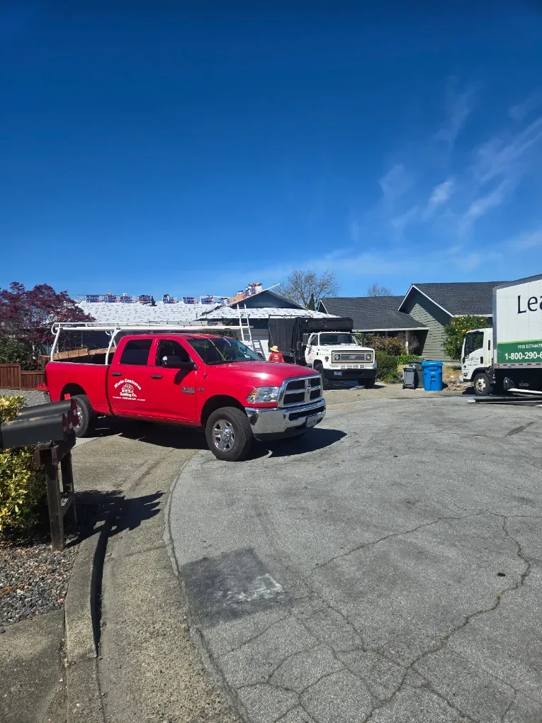 Mario Contreras Roofing red pickup truck at a roofing project